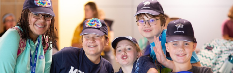 photo of kids in writers academy hats smiling and posing