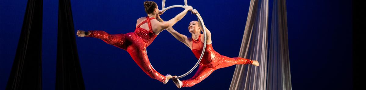Dance students wearing red, doing aerial dance