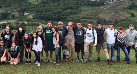 study abroad students posing on a hill