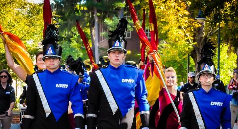 Marching band members holding flags