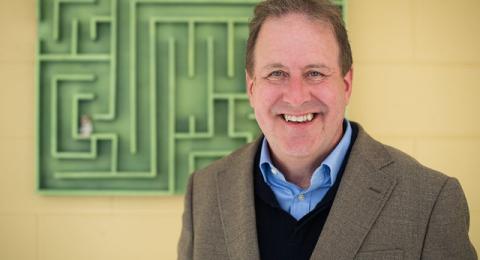 Prof. Mark Henn in front of a wooden maze
