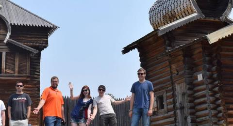 Russian students in front of log cabins