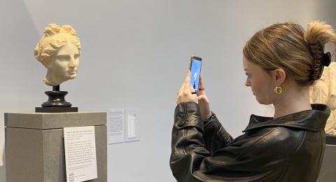 woman taking photo of sculpture