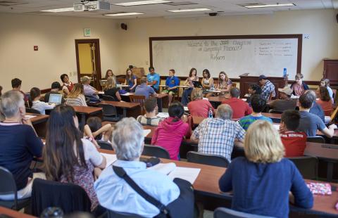 FLI attendees listen to a speaker in a classroom