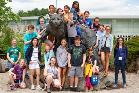 group of children posing with UNH Wildcat statue