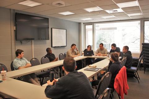 students around conference table talking