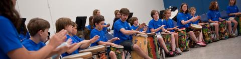 students and teachers playing drums