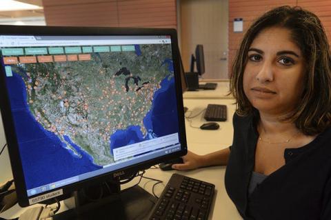photo of Prof Roopika Risam in front of computer showing data map