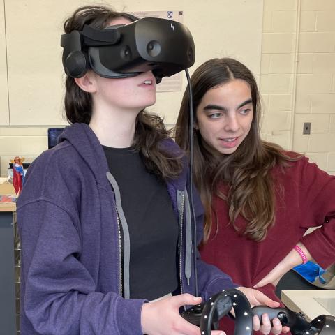 Student wearing a VR headset while another stands next to her