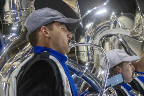 Wildcat Marching Band sousaphone player plays under the lights in Wildcat Stadium