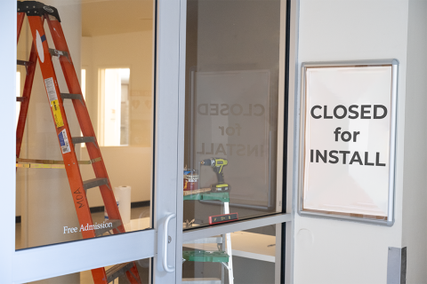 Entrance to art gallery with closed for install sign and ladder