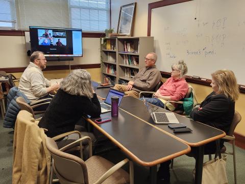 Members of RGSCP's Civics and Citizenship Working Group meeting around a table and online