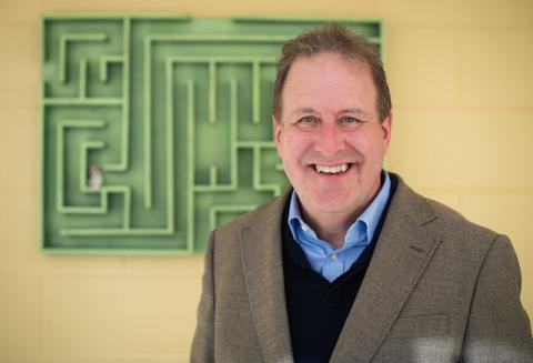 Prof. Mark Henn in front of a wooden maze