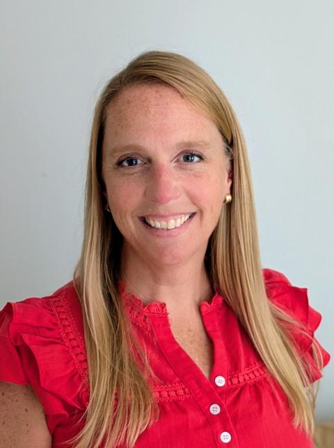 EdD student Kirsten Smith Smiling in front of plain white background wearing a red blouse