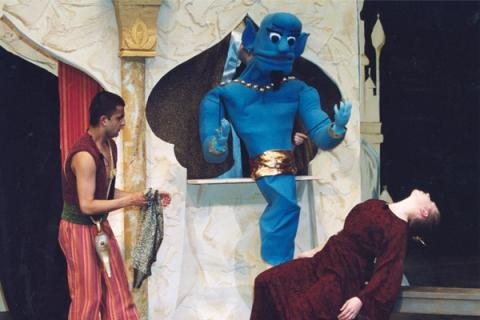Genie puppet and student actor as Aladdin on stage